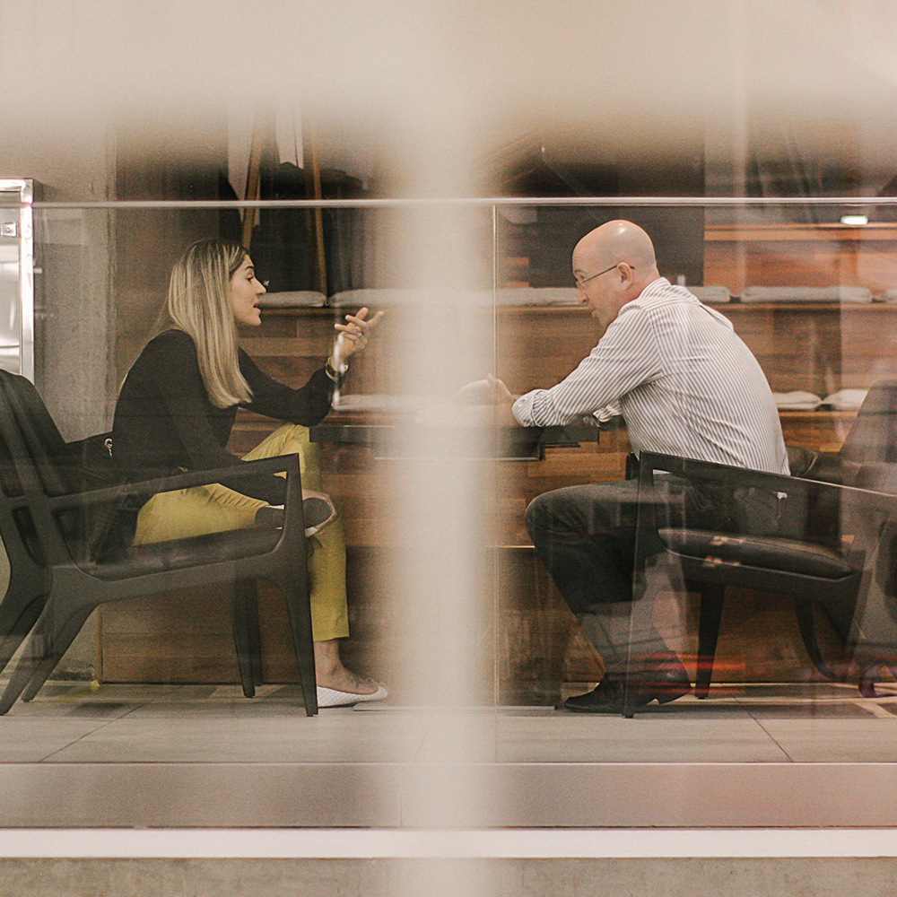 Business meeting viewed through glass office walls